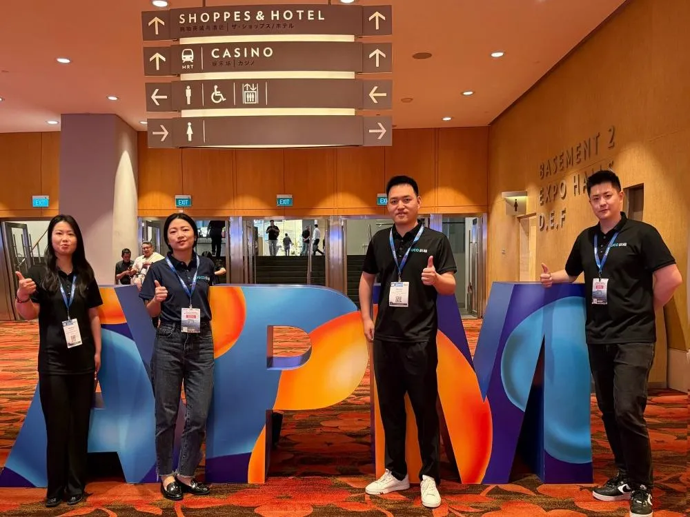 members take a group photo in front of the APM logo