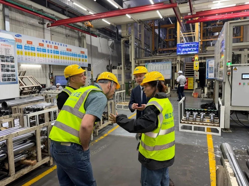 Visitors in safety gear discussing operations on the factory floor