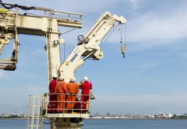 Engineers conducting on-site load testing and commissioning for a folding boom crane